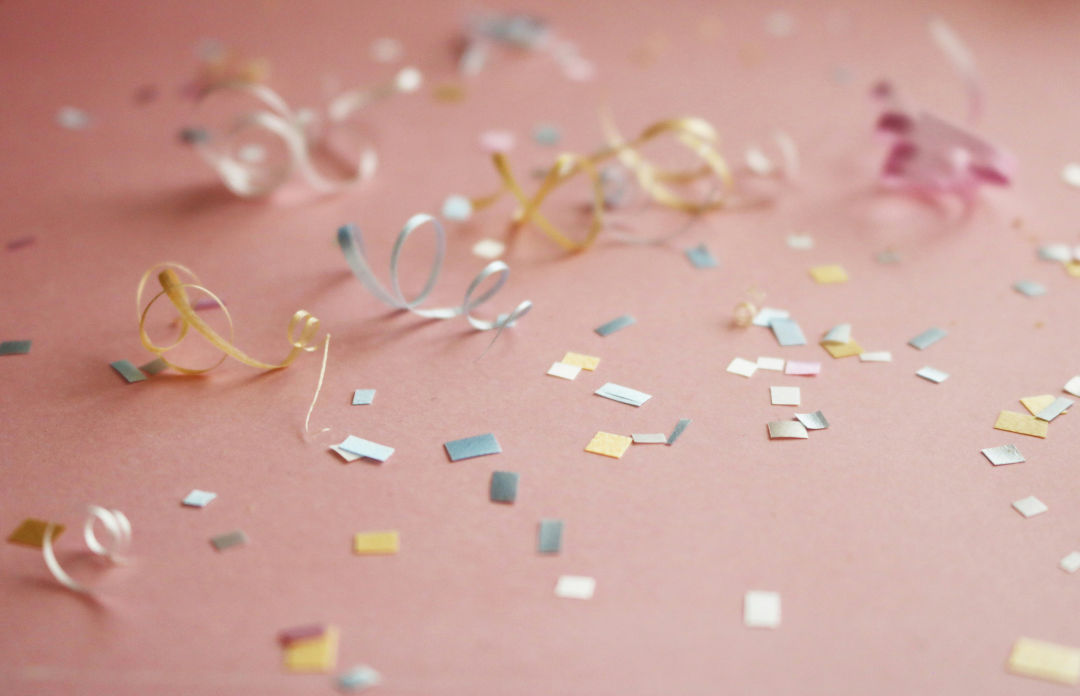 Confetti scattered across a pink table after a graduation party