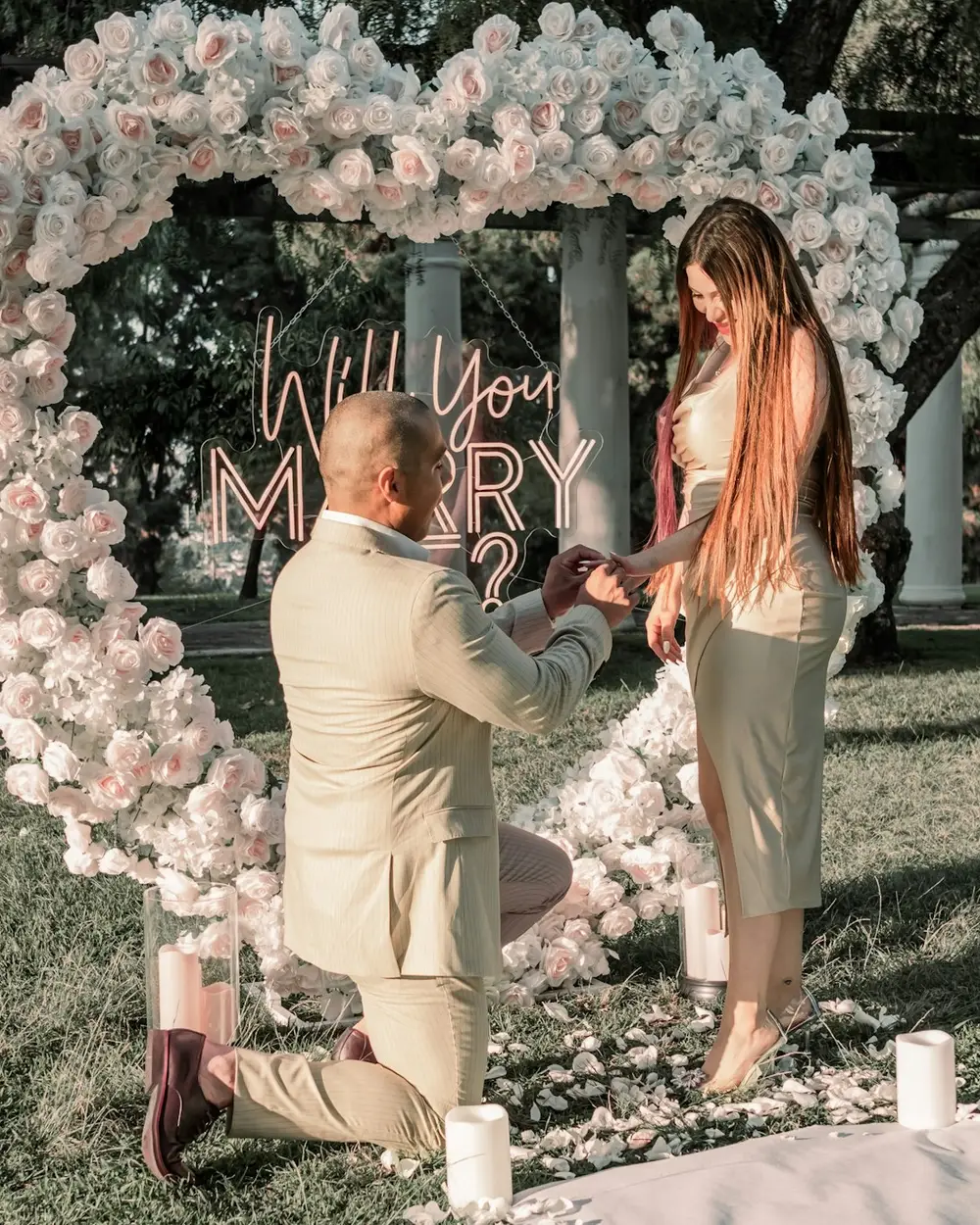 A surprise proposal in front of a heart-shaped floral arch, shared to a live Dropola gallery