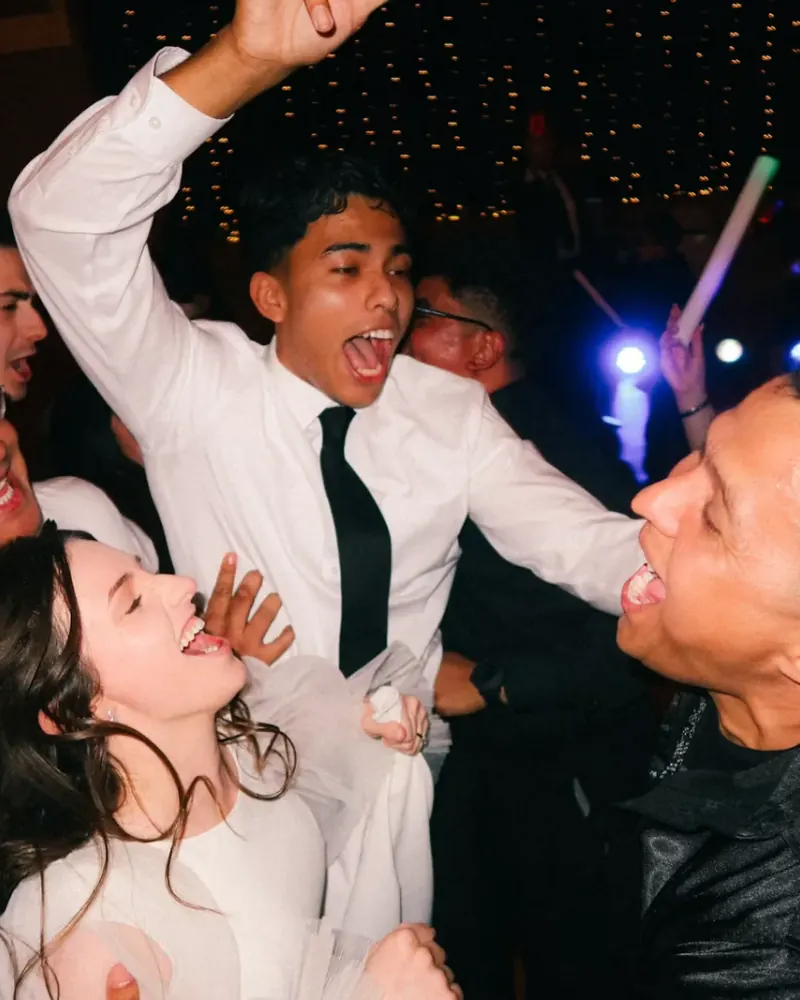 Guests dancing and posing for photos at a wedding party